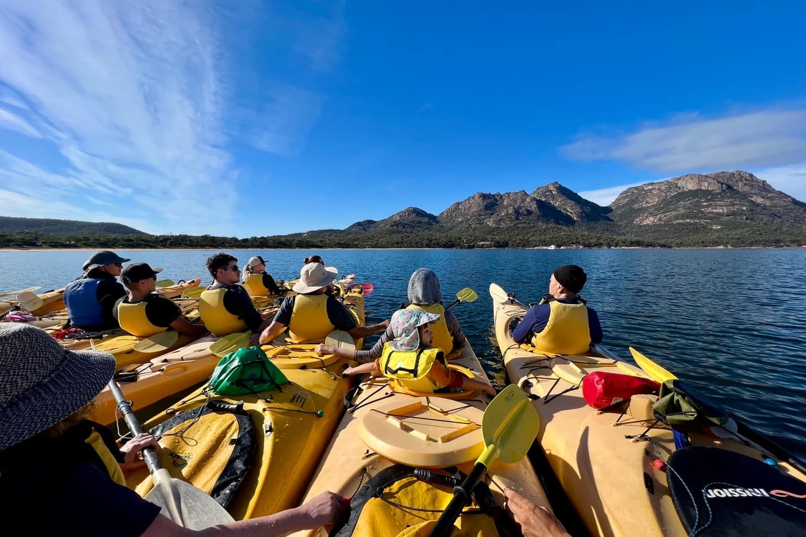 Family kayaking in the bay at Coles Bay