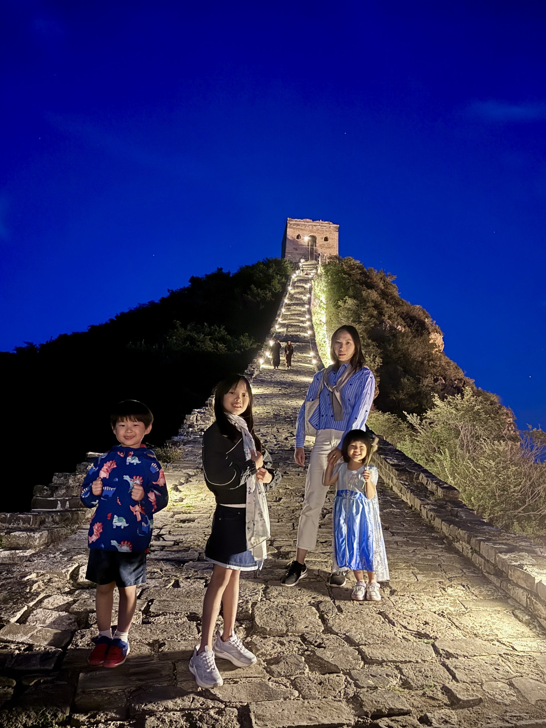 My wife and the children on the illuminated Great Wall at night