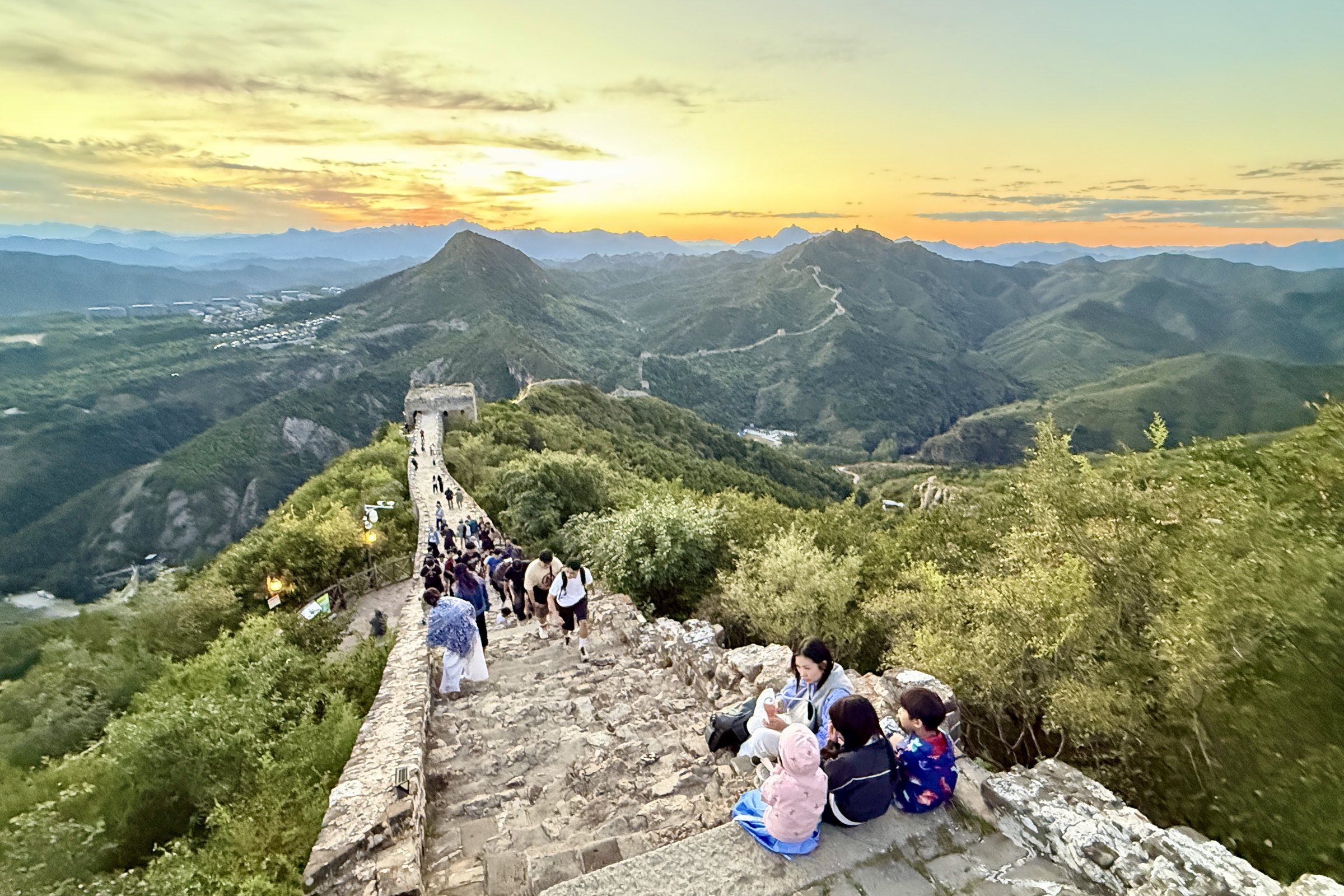 The family having a picnic on the Great Wall at sunset