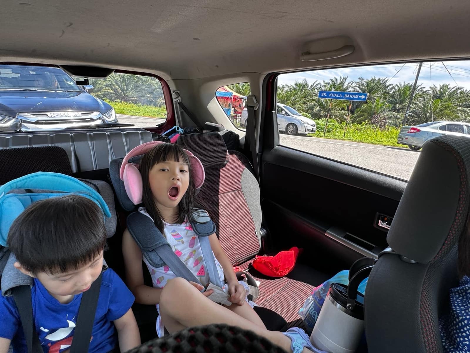 Sophie and George in the back of the rental car on the drive from Miri into Brunei