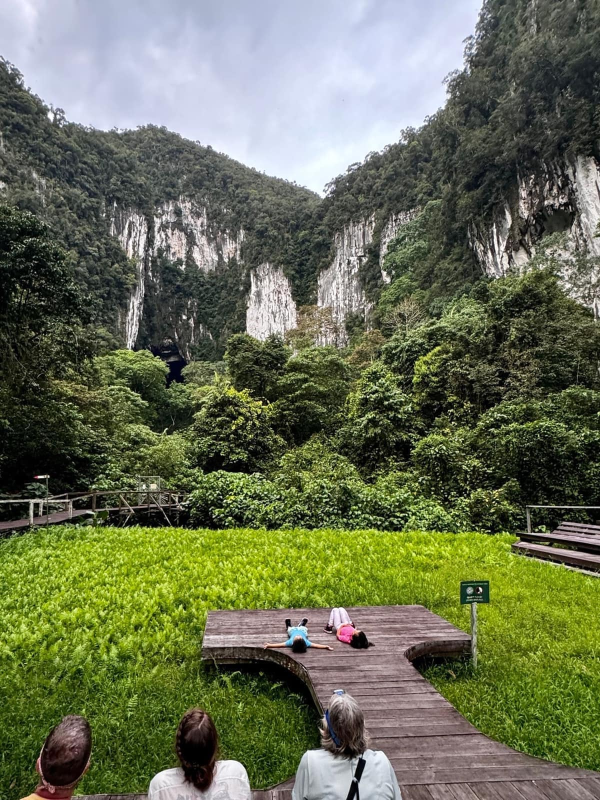 Sophie and George lying on the viewing platform while waiting for bats to leave Deer Cave