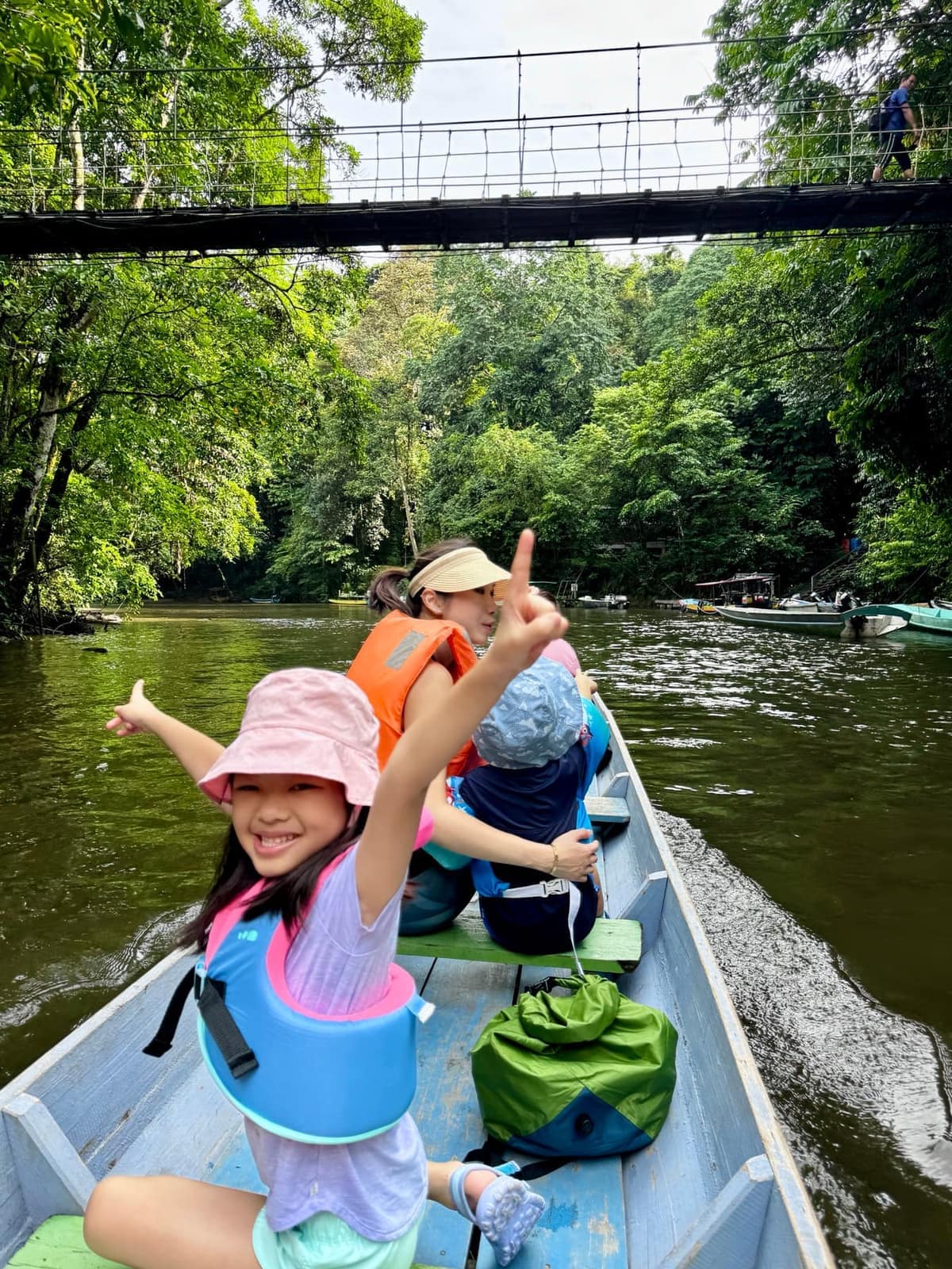 The family riding along the Melinau River by longboat
