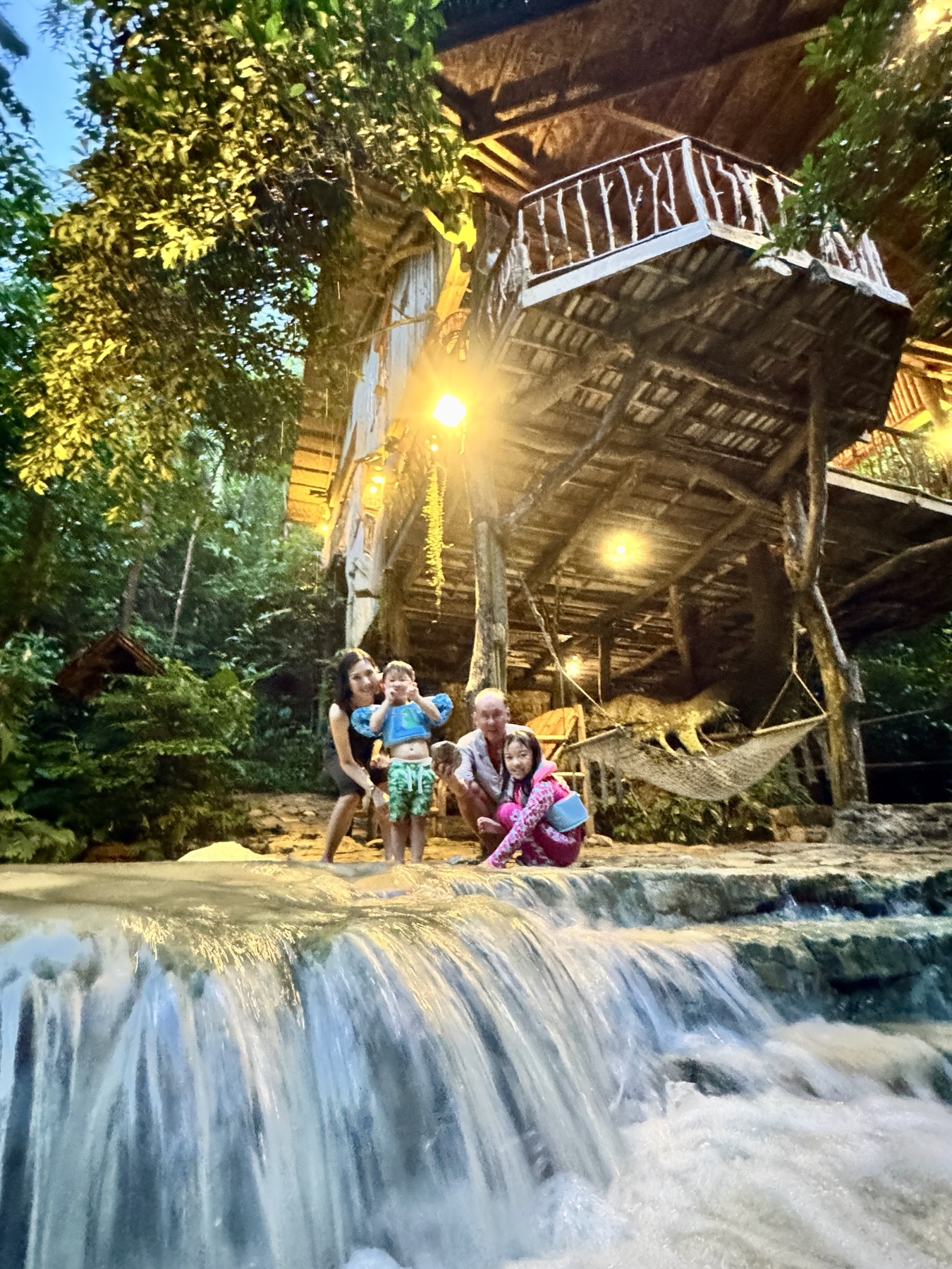The family beside the stream beneath their open-sided house in the Balamban hills