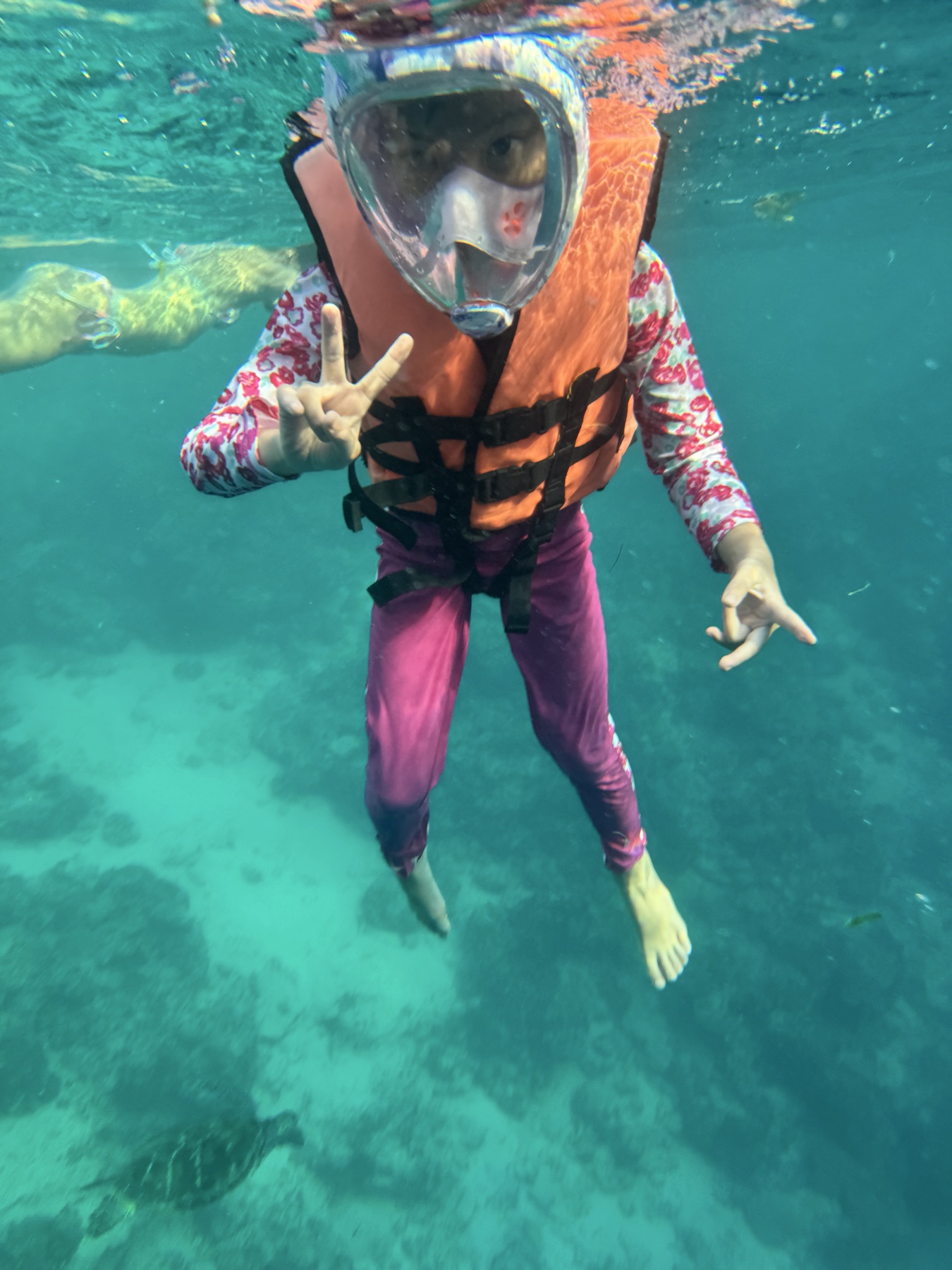 Sophie swimming beside a turtle off Moalboal