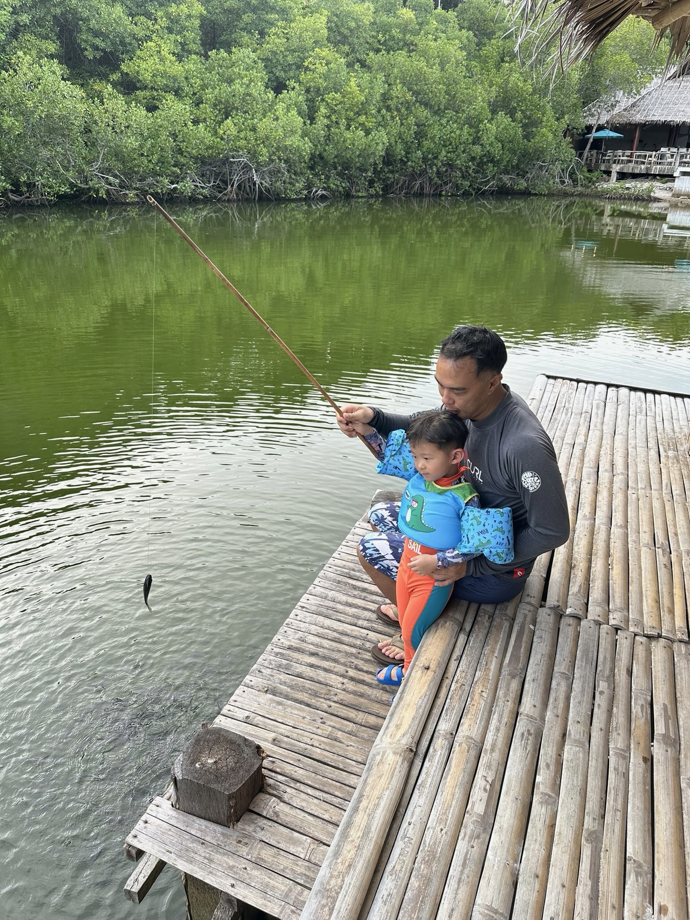 Philip and George catching small fish together from a bamboo platform on Sumilon Island