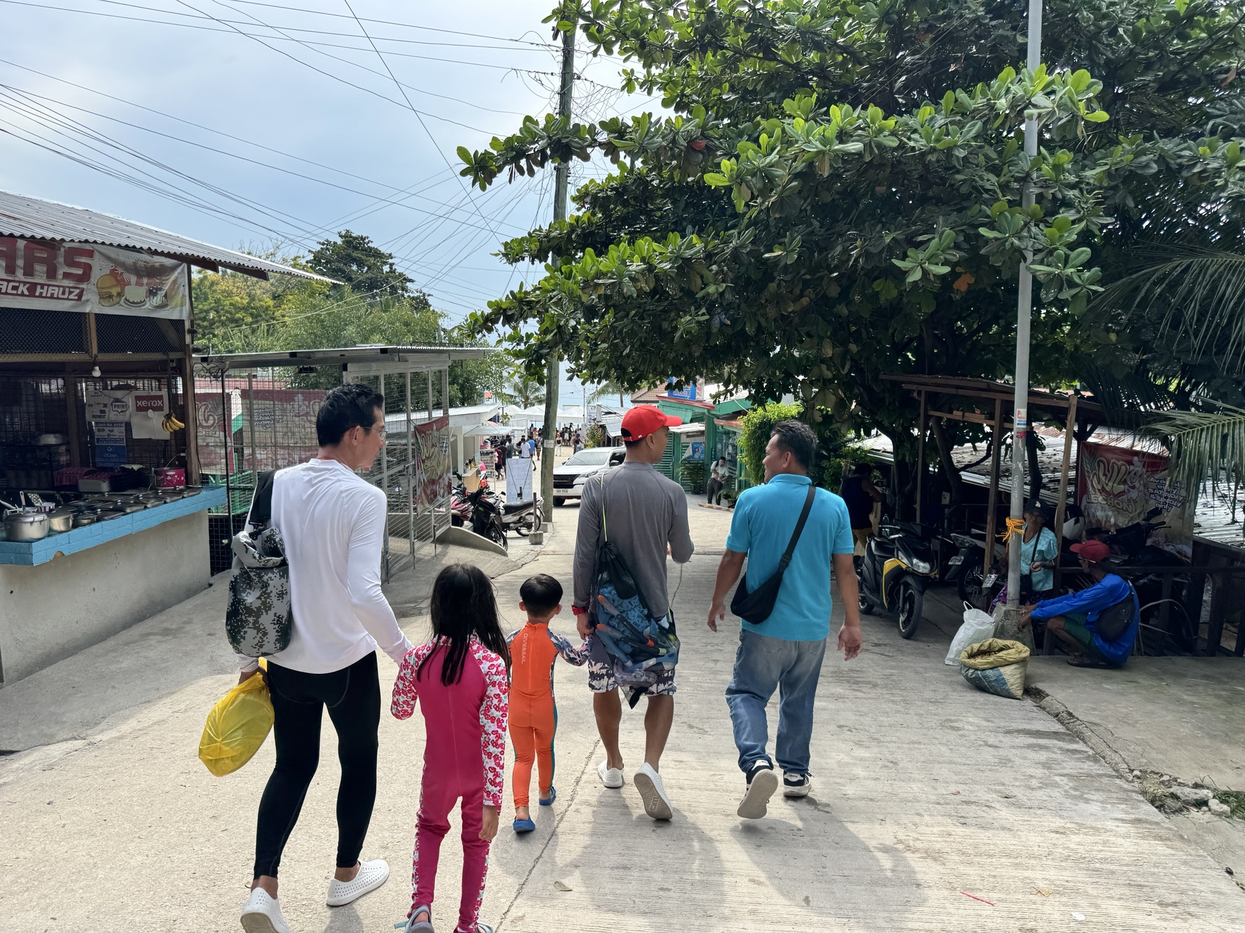 The family walking down through Oslob towards the shore