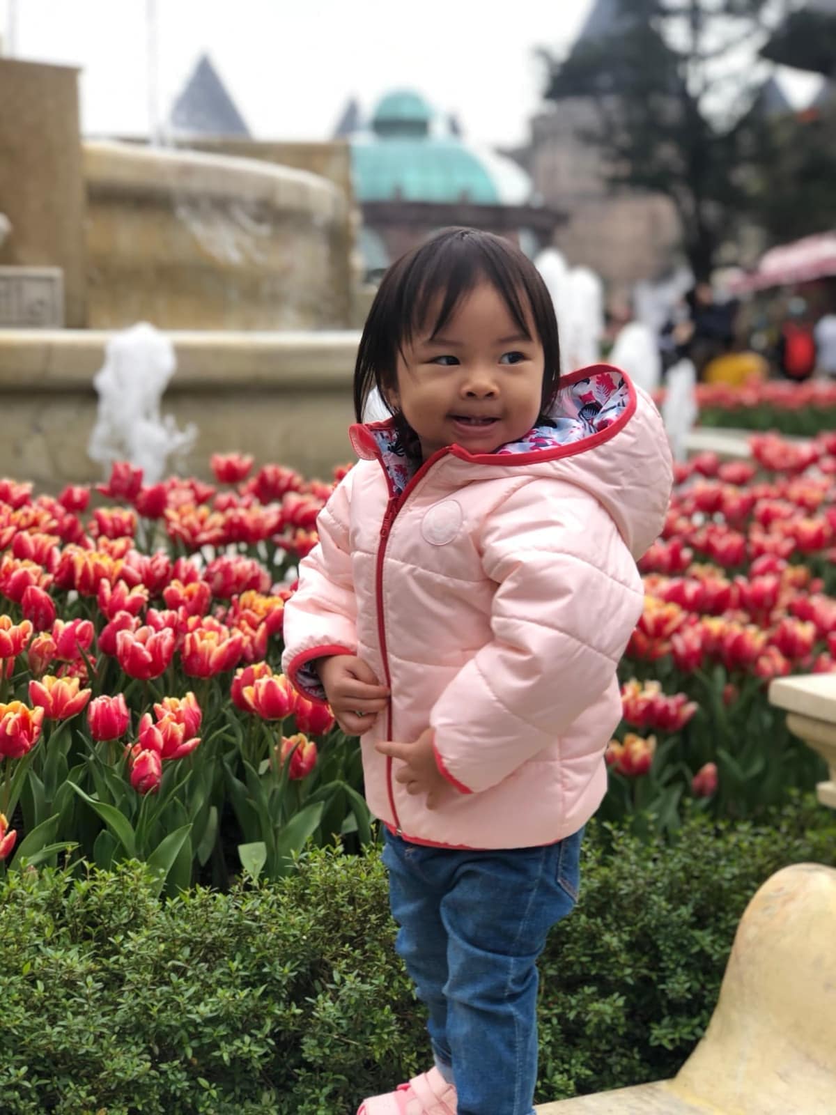 Sophie standing among red tulips at Ba Na Hills