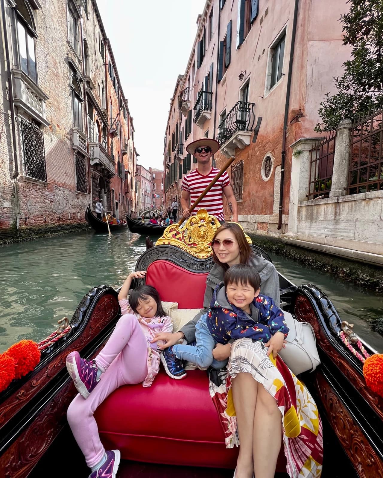 The family travelling by gondola in Venice