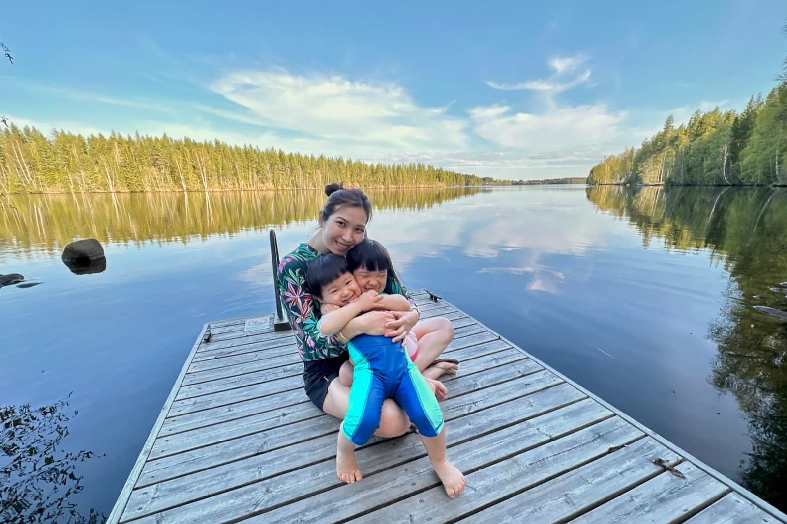 The family sitting on a lakeside jetty in Finland