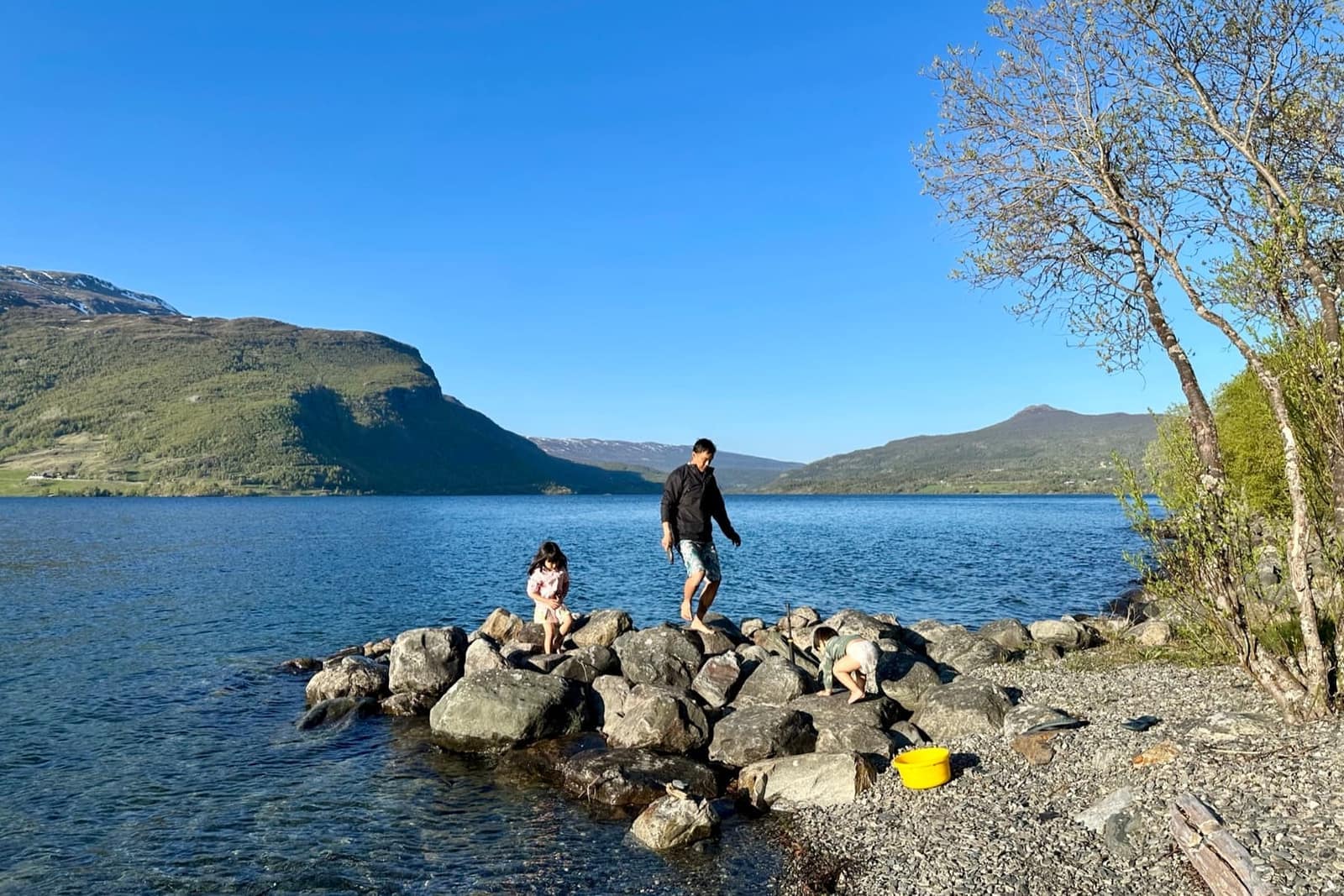 The family playing beside a Norwegian lake at eight in the evening