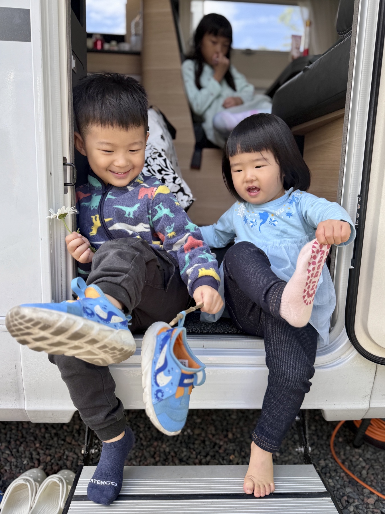 The children sitting in the motorhome doorway