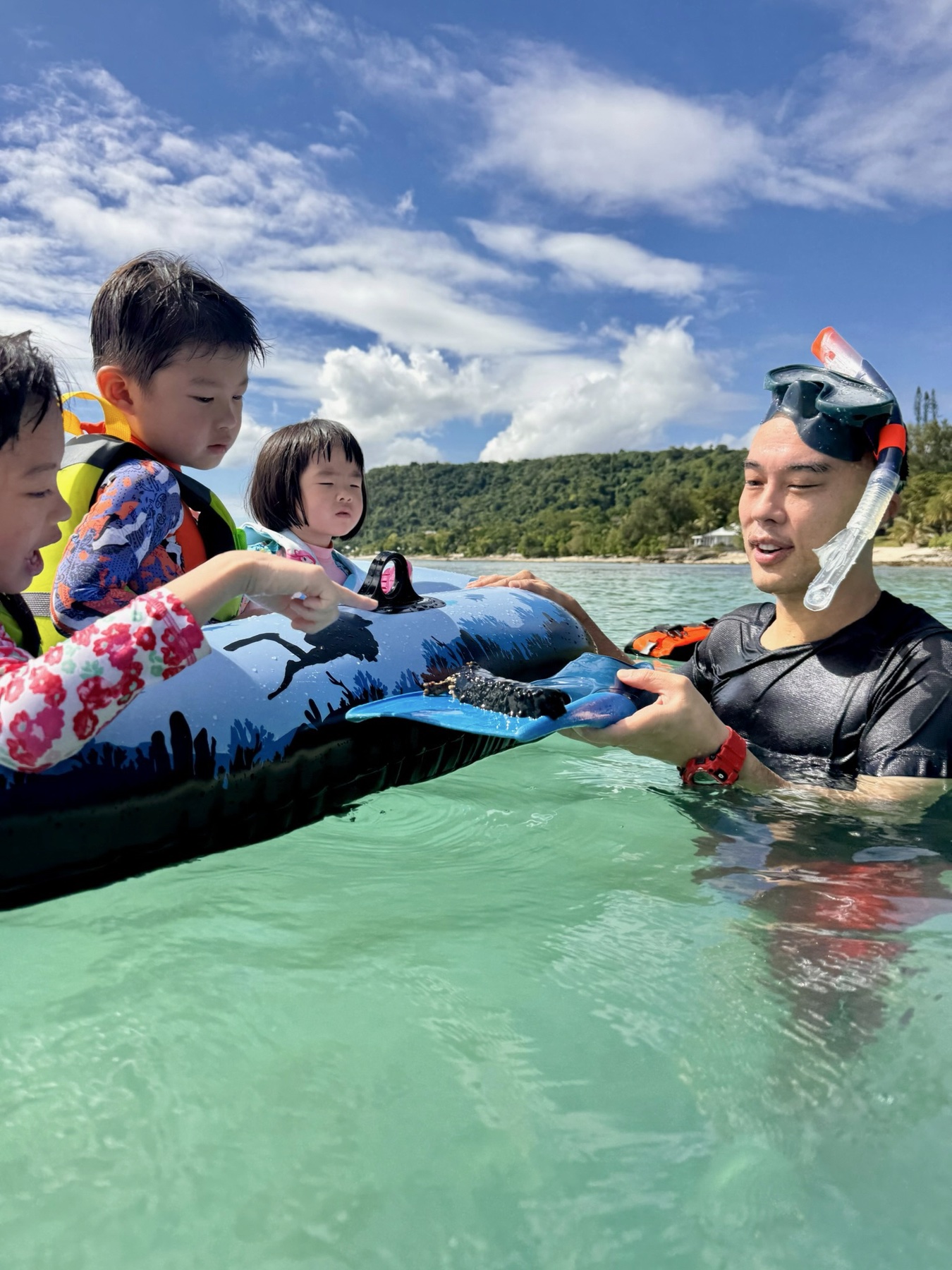 Children looking at a sea cucumber at Samoa’s Giant Clam Sanctuary