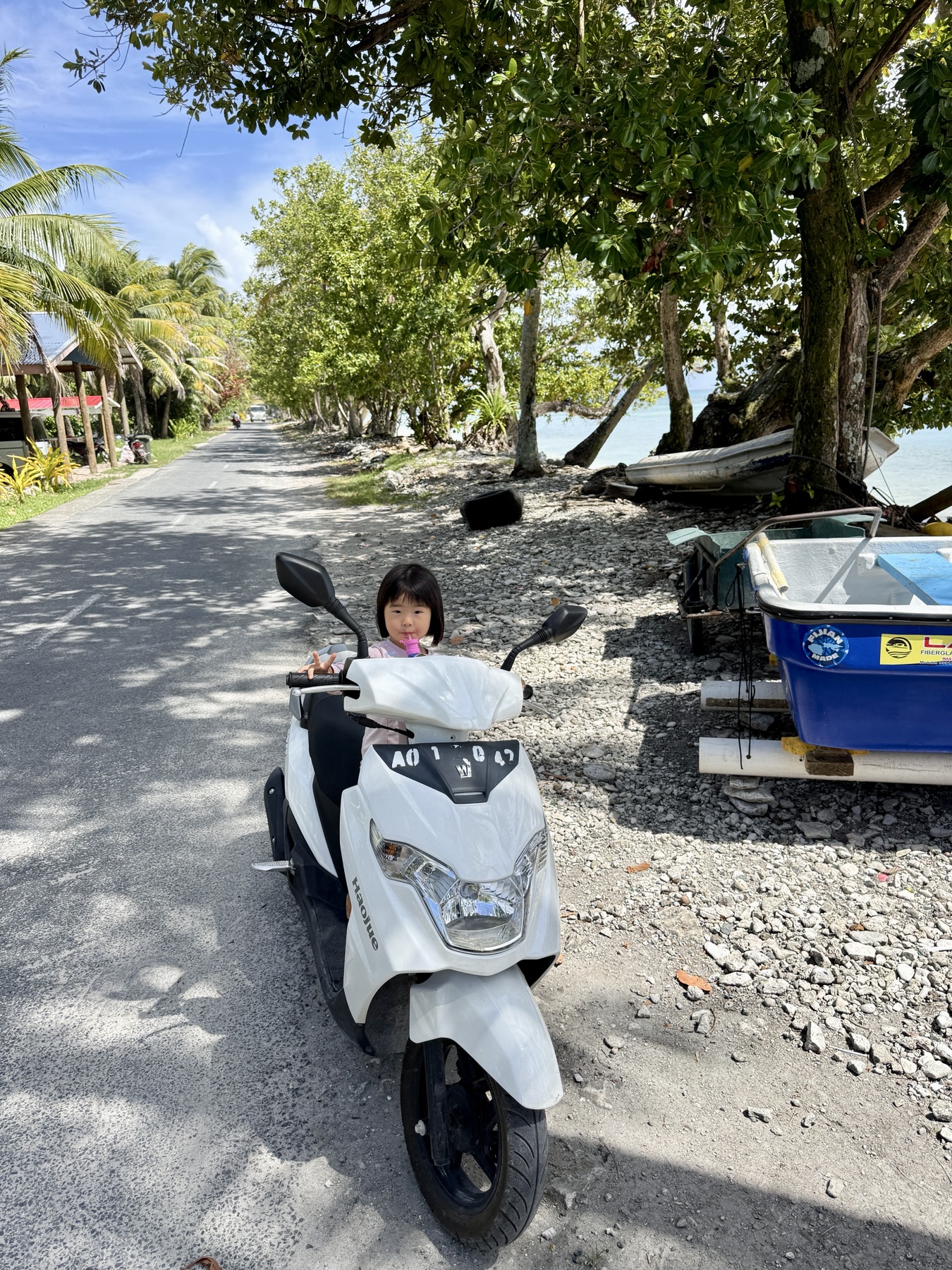 Claire riding on a scooter in Tuvalu