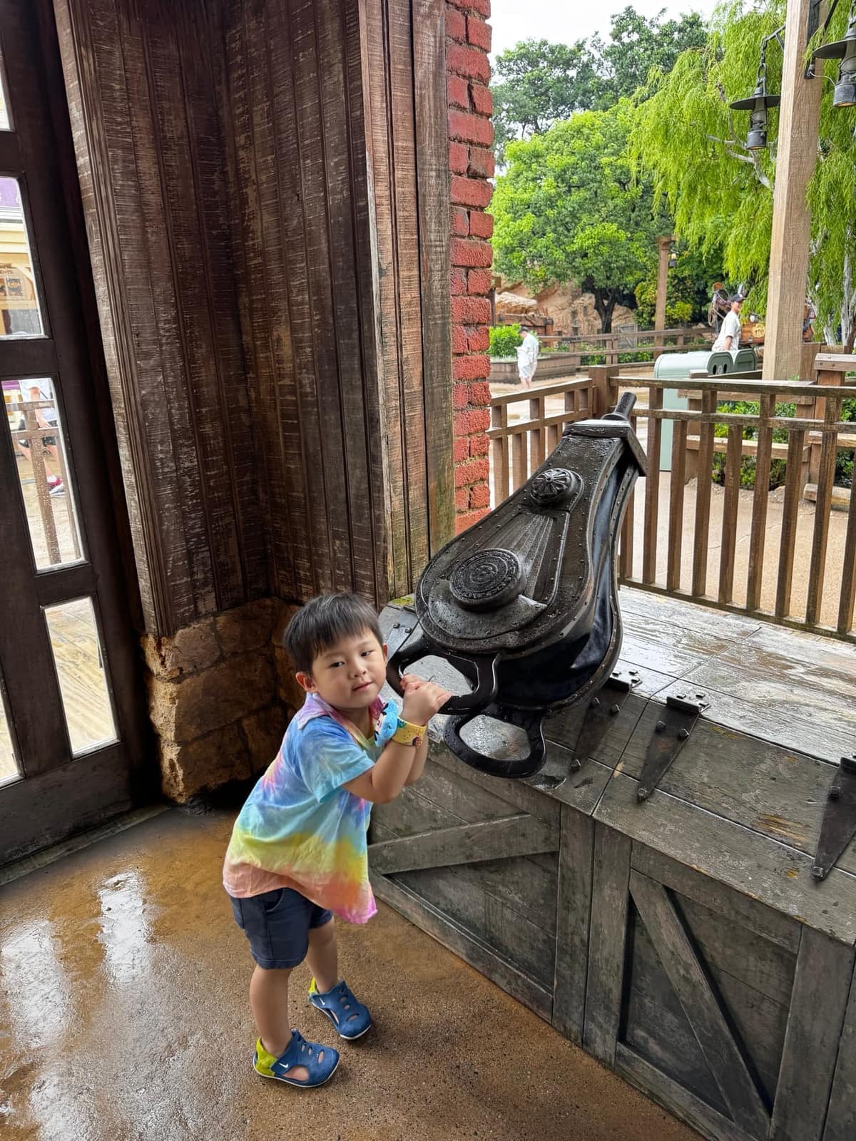 George stopping to look closely at a black bird figure in Disneyland