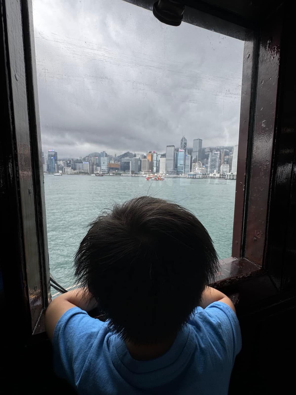 George looking through the ferry window across Victoria Harbour