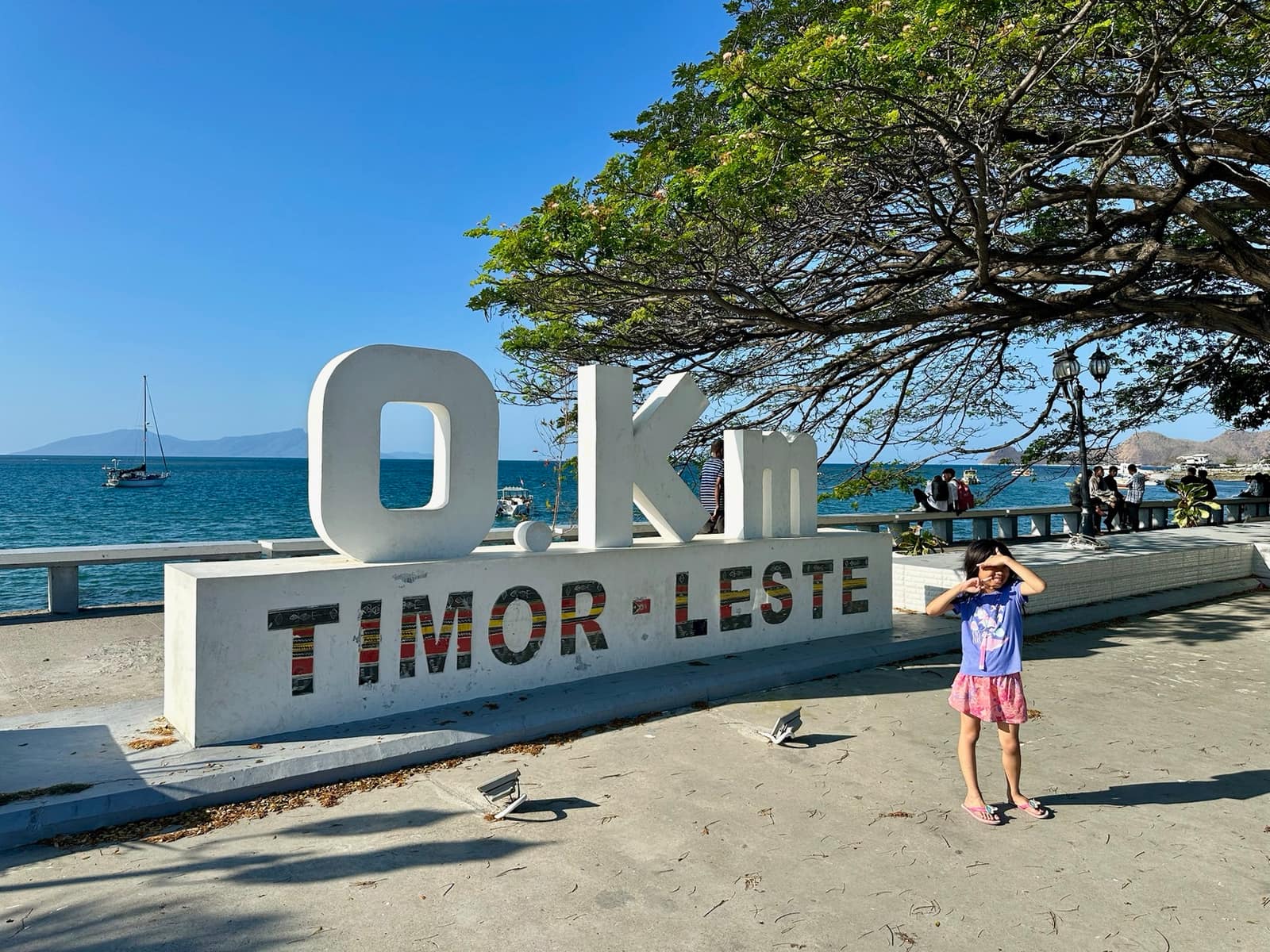 Sophie beside the Timor-Leste sign on Dili’s waterfront