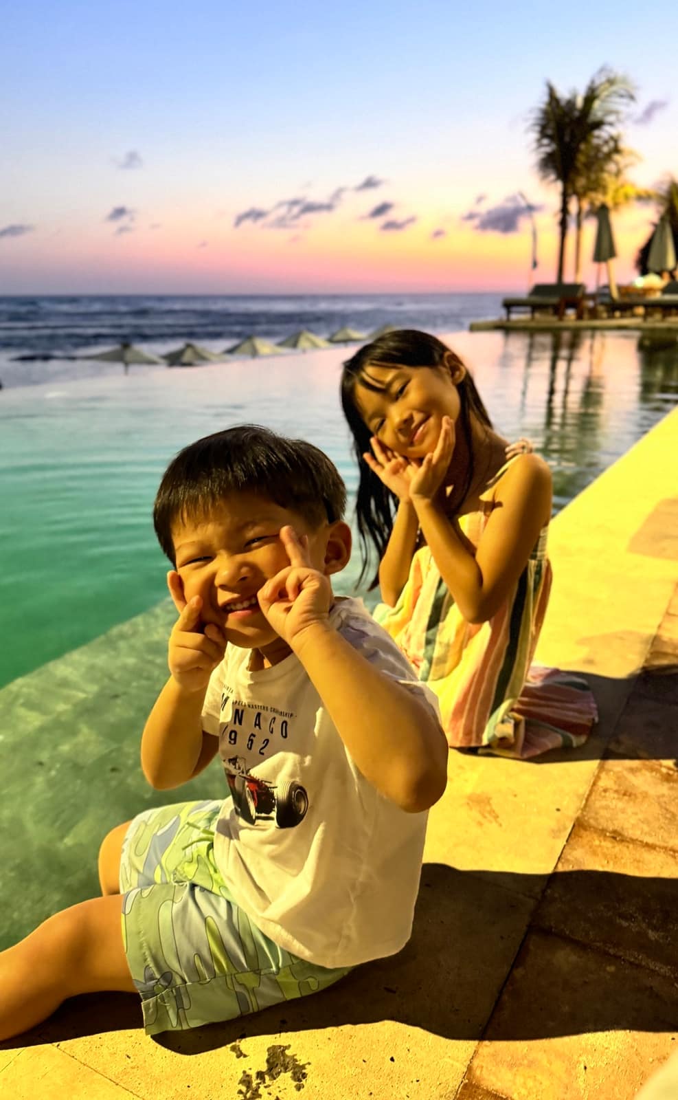 George and Sophie sitting together by the pool in Bali at dusk