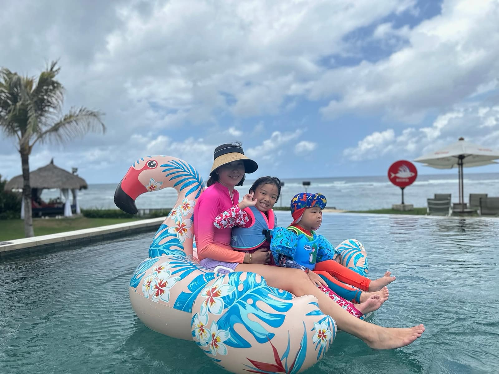 Vanessa and the children sitting together on an inflatable in the hotel pool