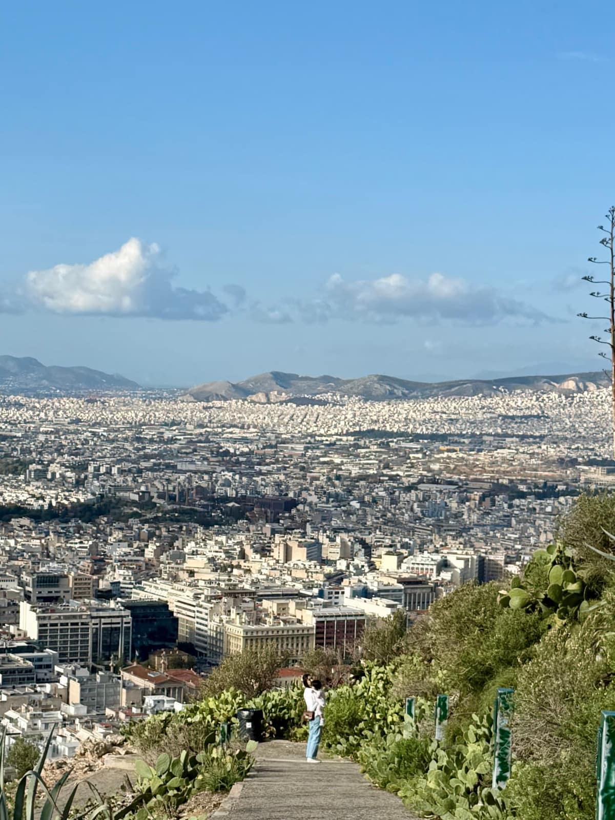 Vanessa holding Claire on the path down Lycabettus Hill with Athens below
