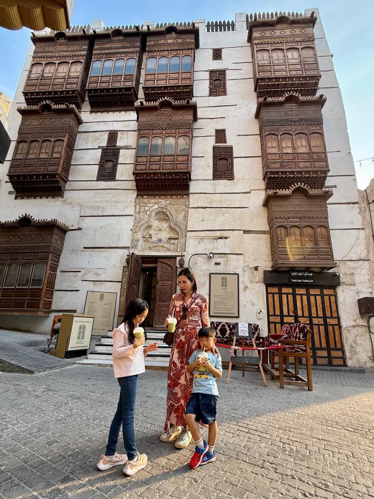 Vanessa and the children drinking juice in front of a traditional house in Al-Balad