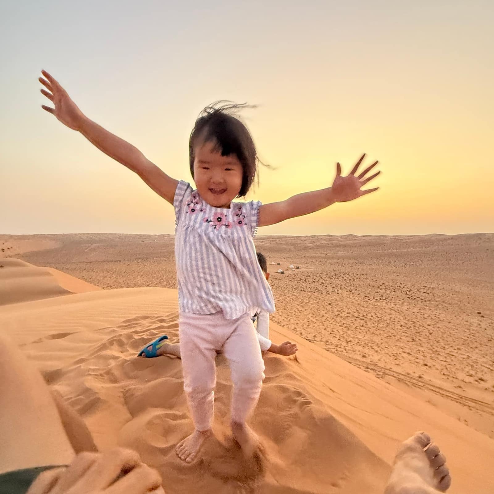 Claire running along the dune with both arms outstretched