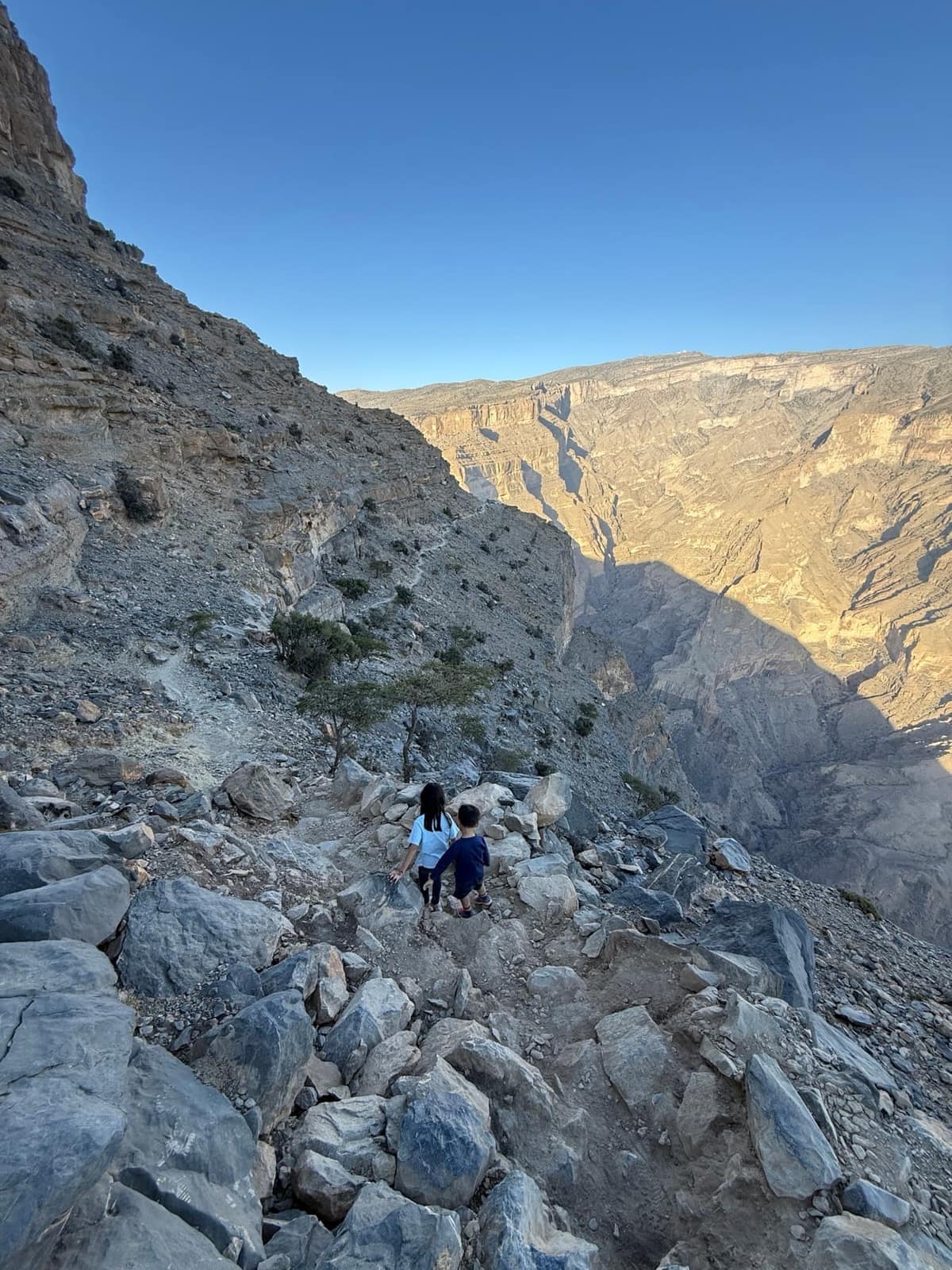 Sophie and George carefully walking down the rocky Jebel Shams trail