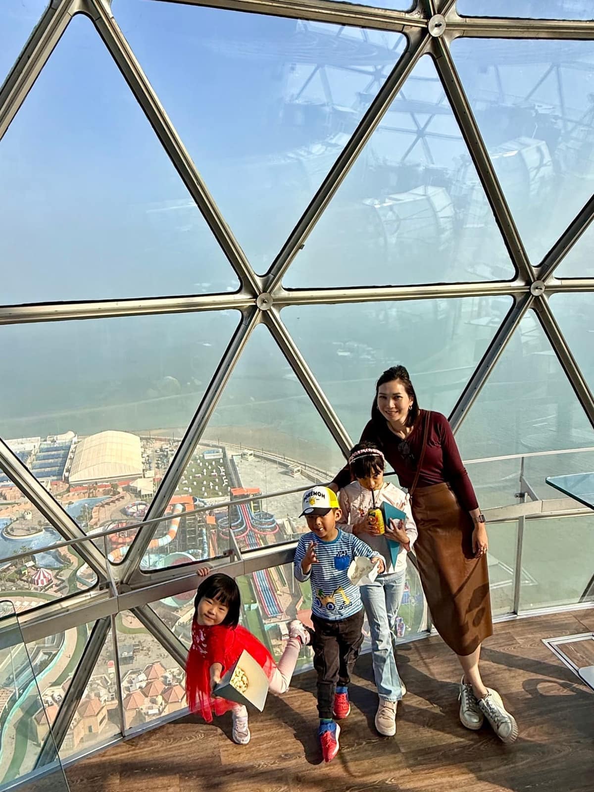 Vanessa and the children together inside the geometric observation deck at Kuwait Towers