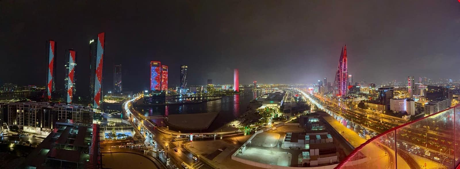 A wide nighttime view over Bahrain and its illuminated roads
