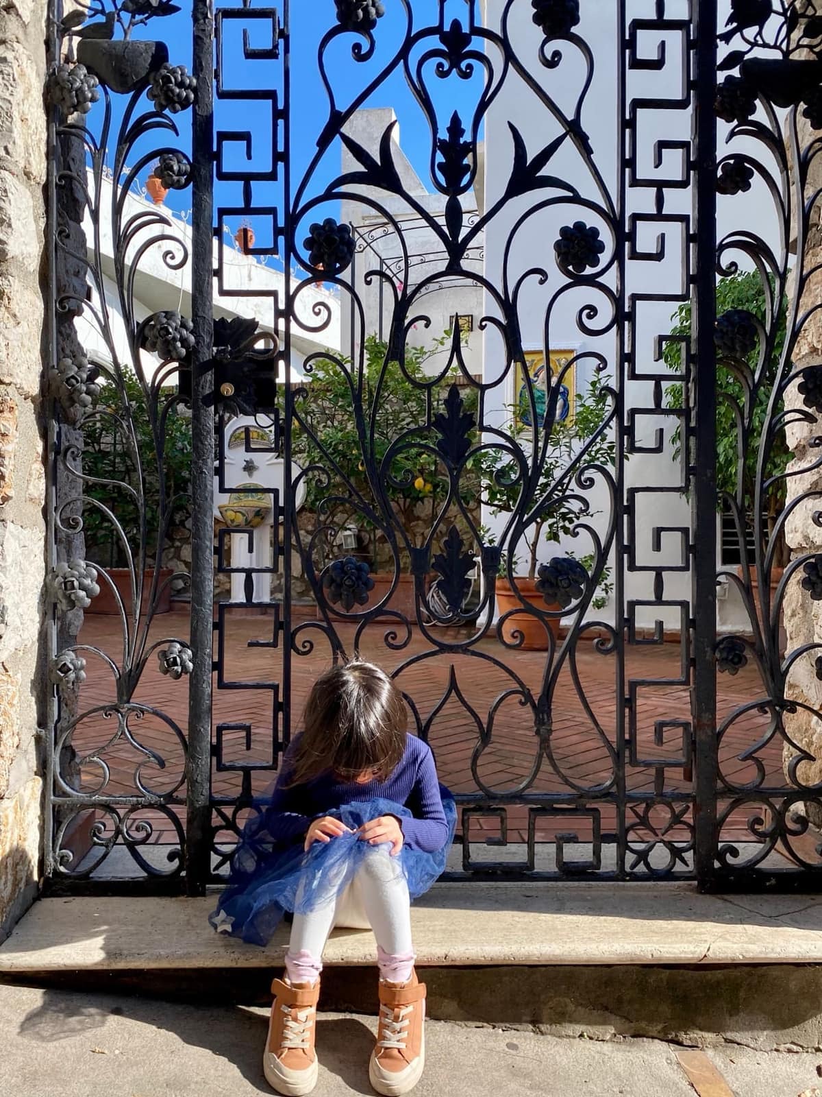 Sophie pausing by a gate in Capri