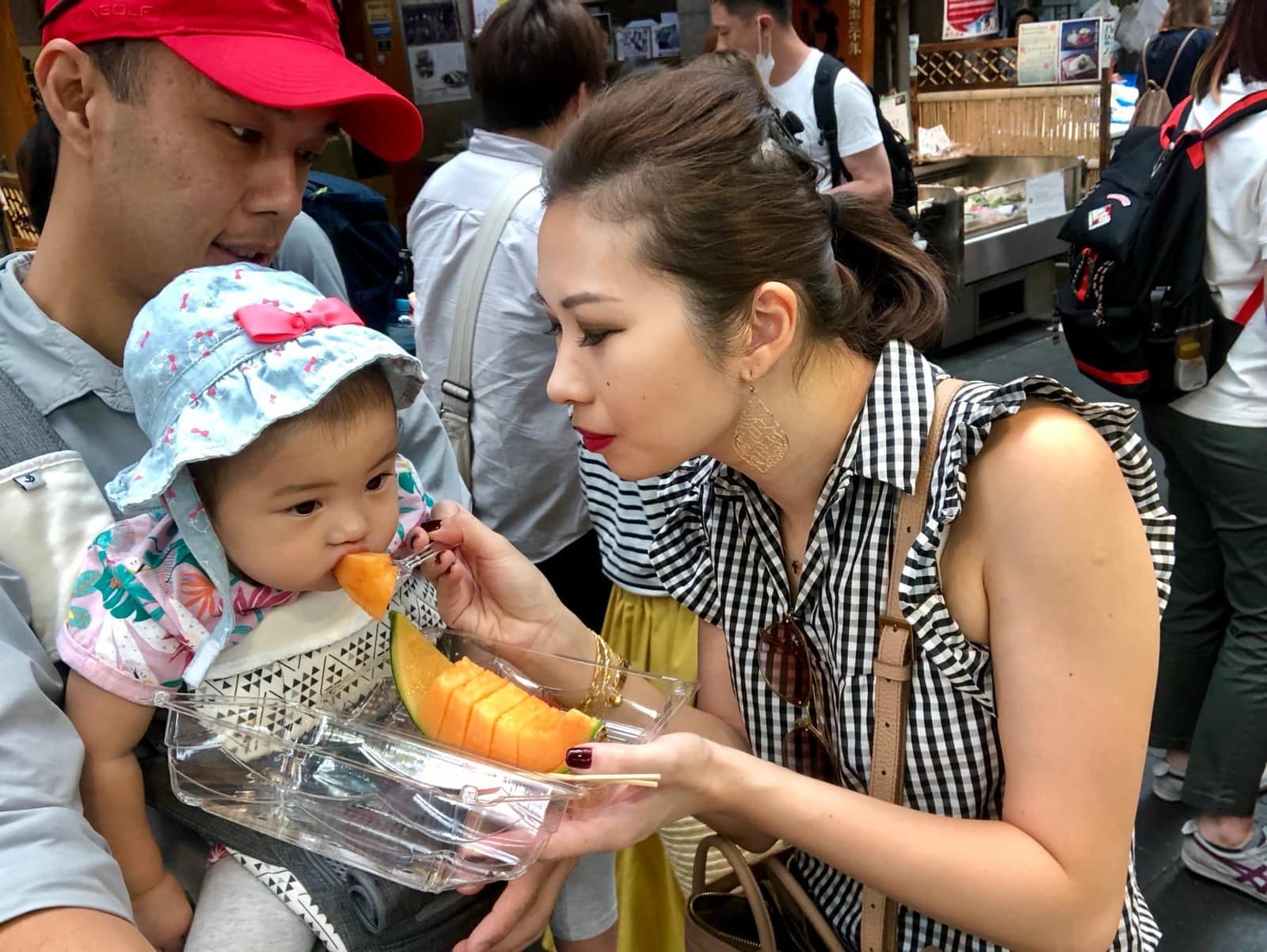 Philip and Vanessa feeding Sophie melon at a food stall in Osaka