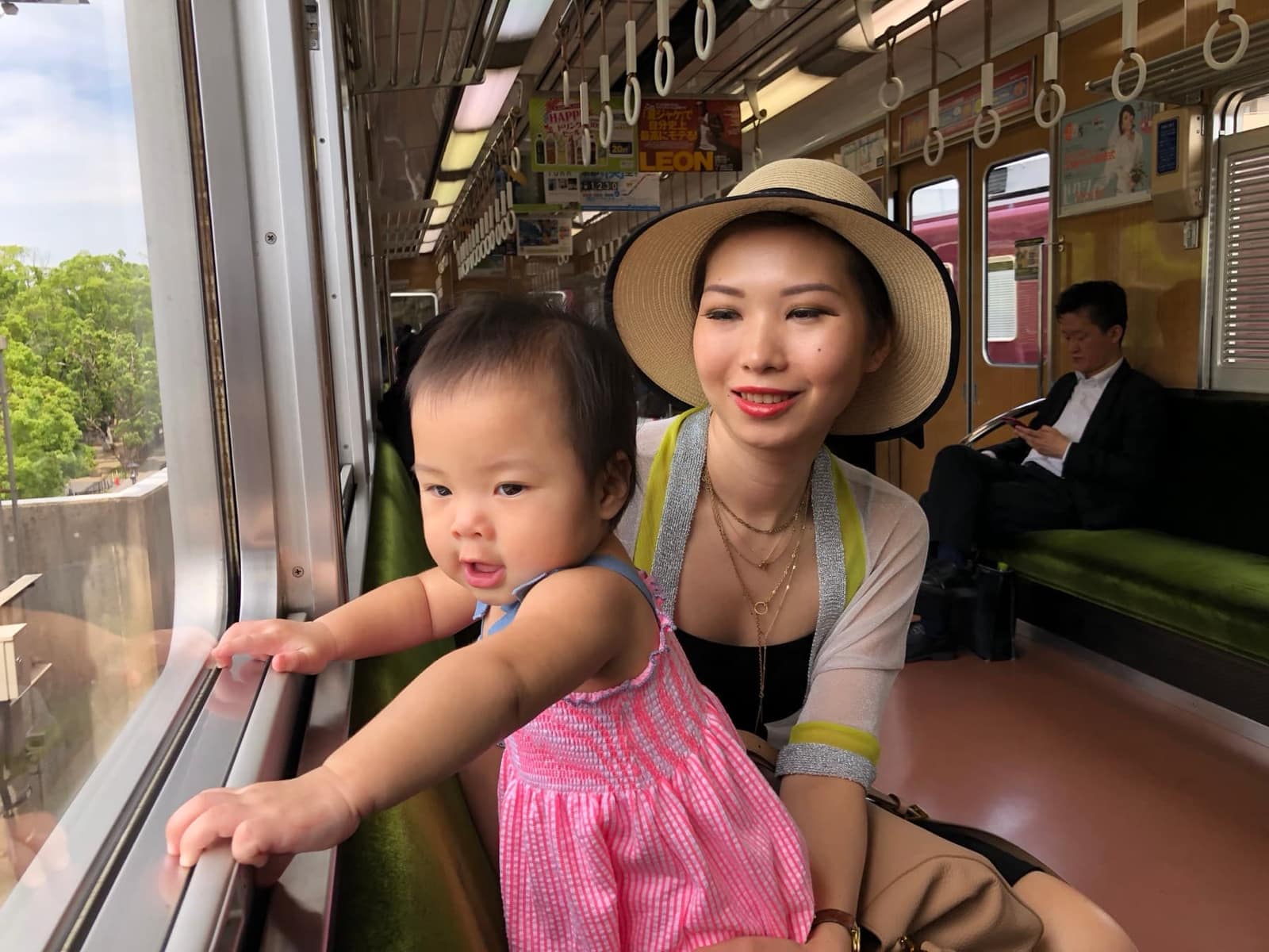 Vanessa holding Sophie beside the window on the train from Osaka to Kyoto