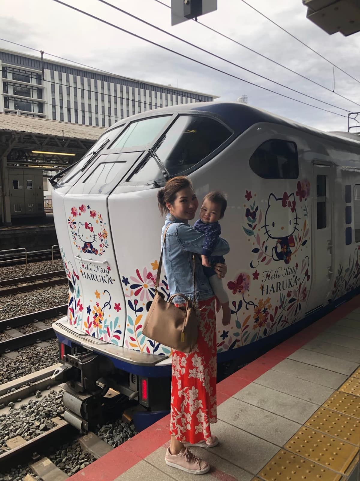 Vanessa holding Sophie beside the Hello Kitty Haruka at Kyoto Station