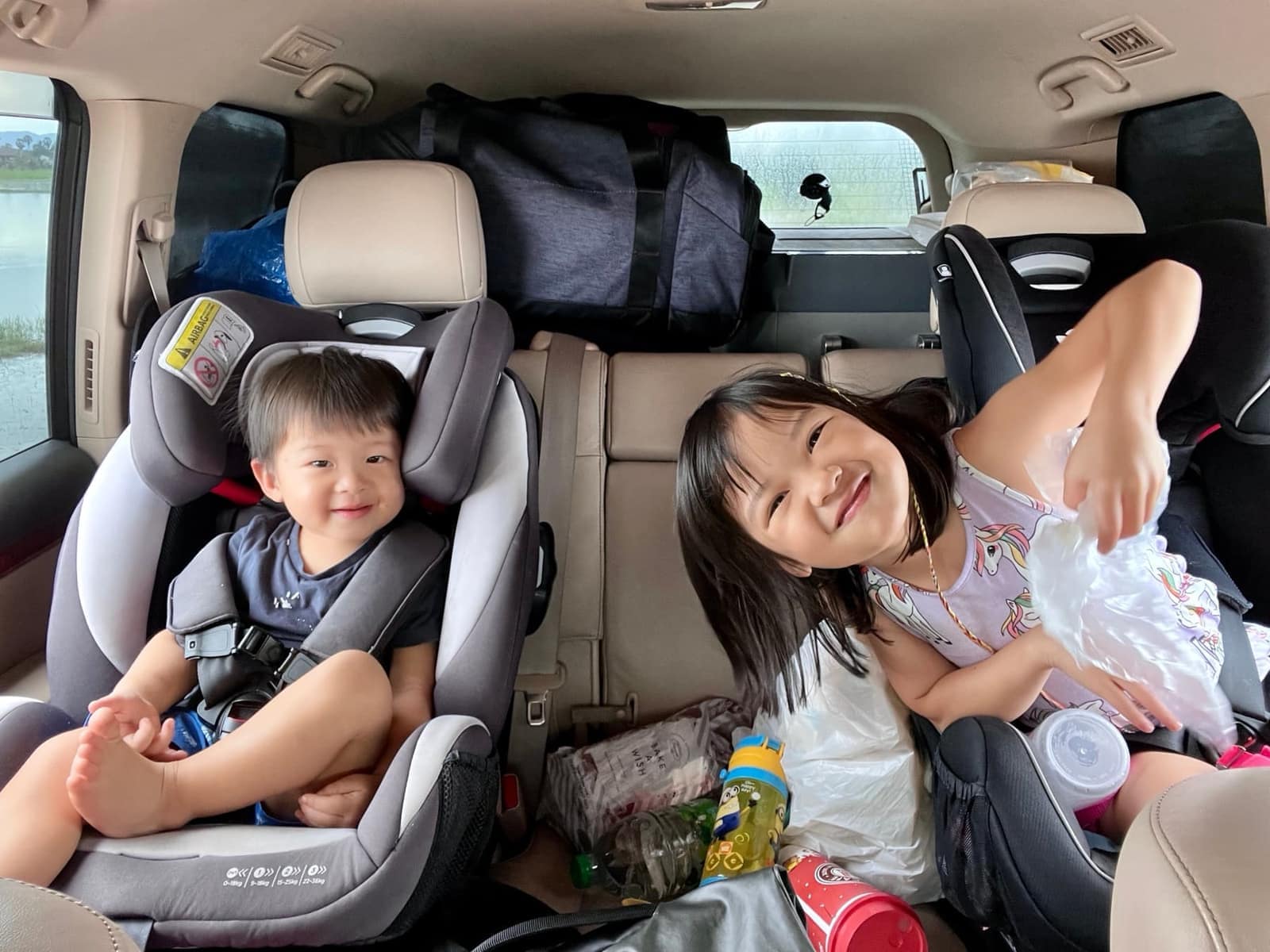 Sophie and George awake and smiling in the car on the way home