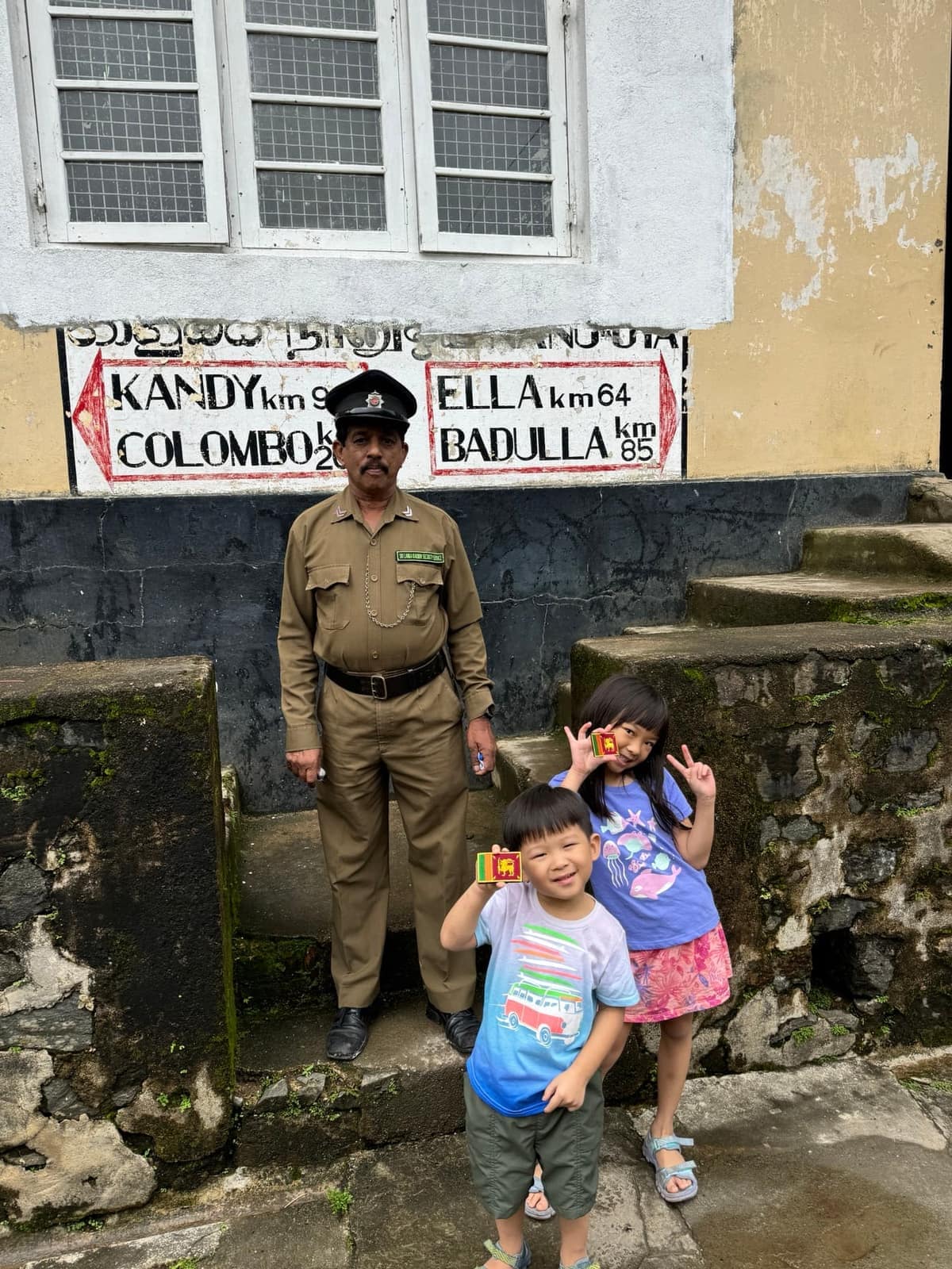 Sophie and George with a railway guard below destination signs
