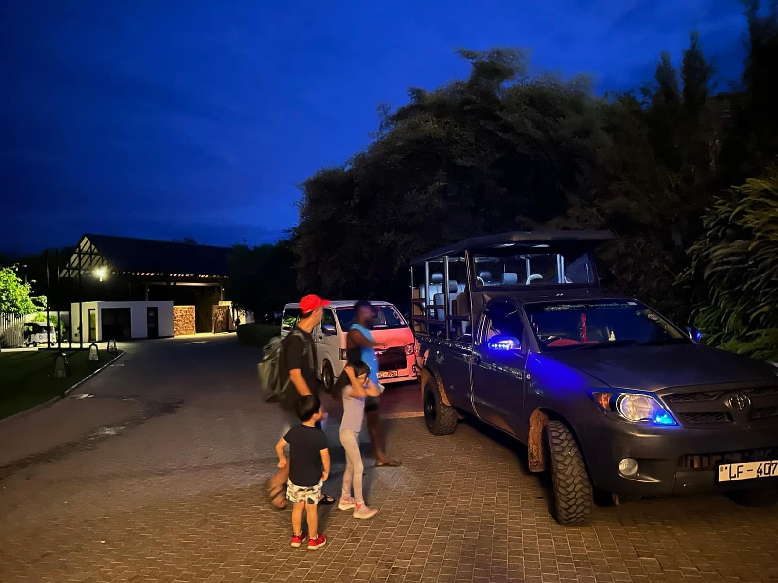 The family outside their hotel beside a waiting safari jeep before sunrise