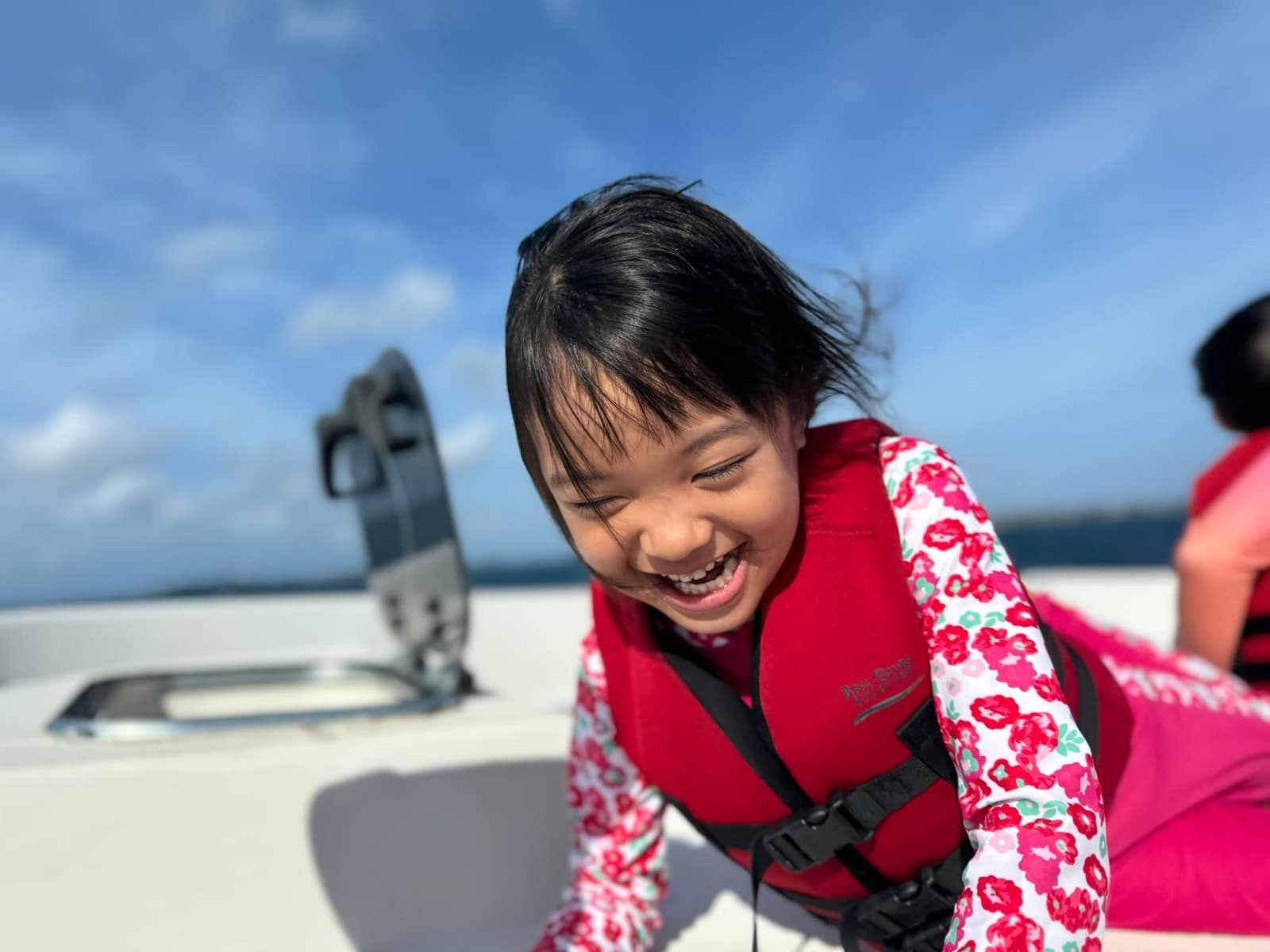 Sophie laughing in her life jacket on the boat journey back to the hotel