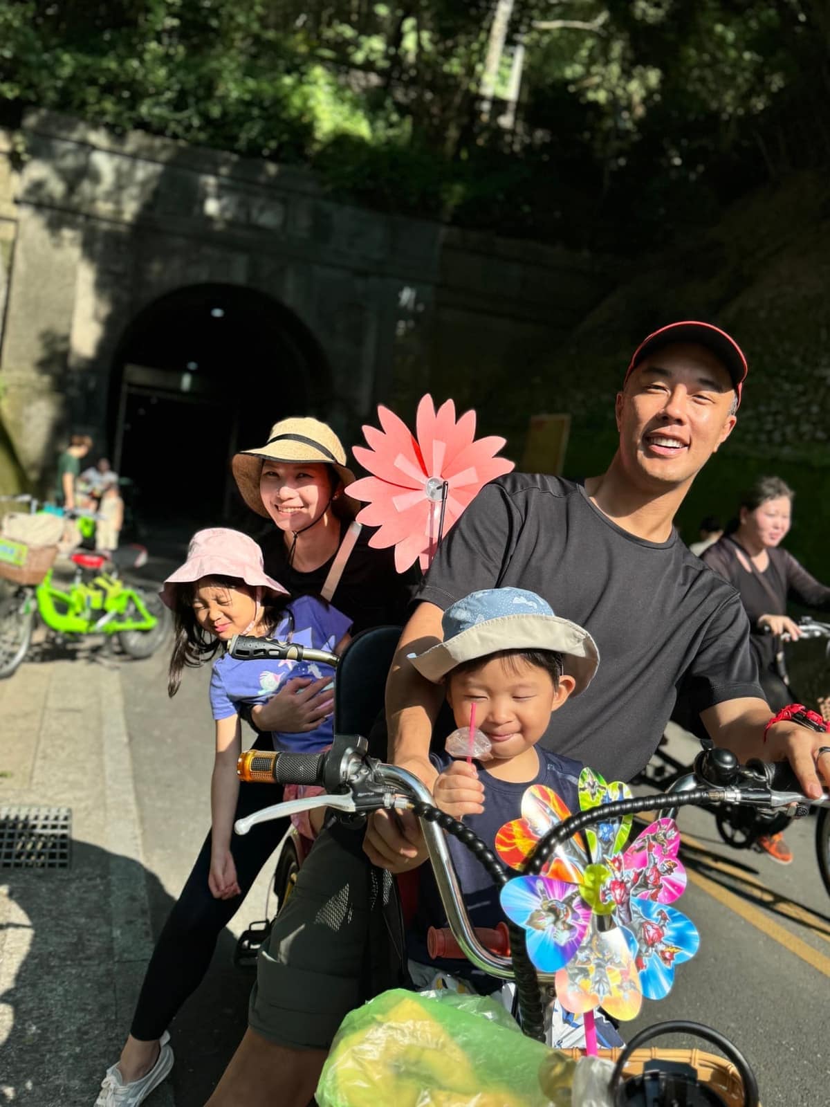 The family stopped together on a multi-seat bicycle along the Houfeng Bikeway