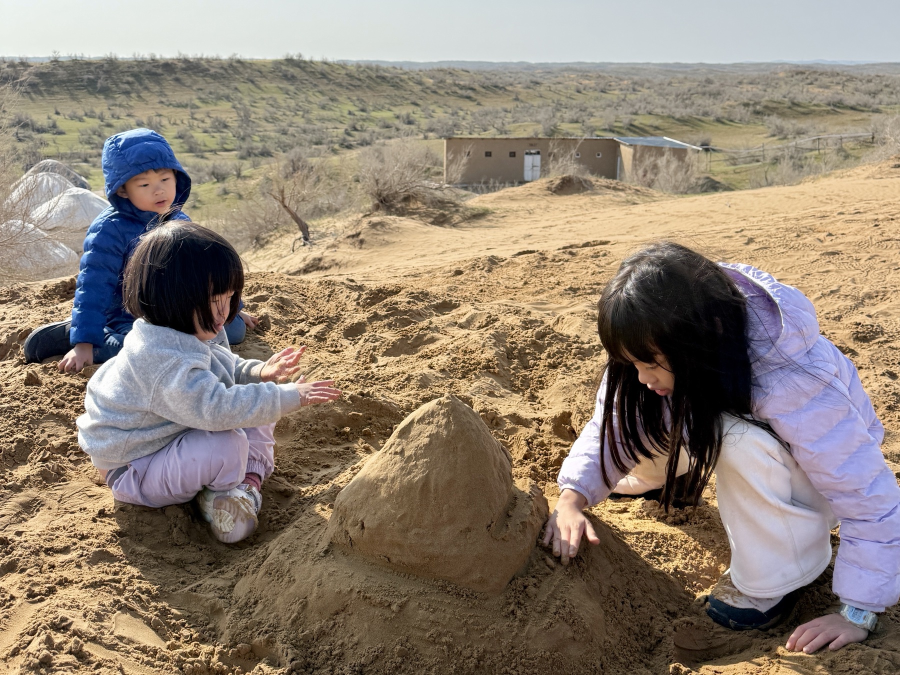 Children playing in sand dunes in the Kyzylkum Desert
