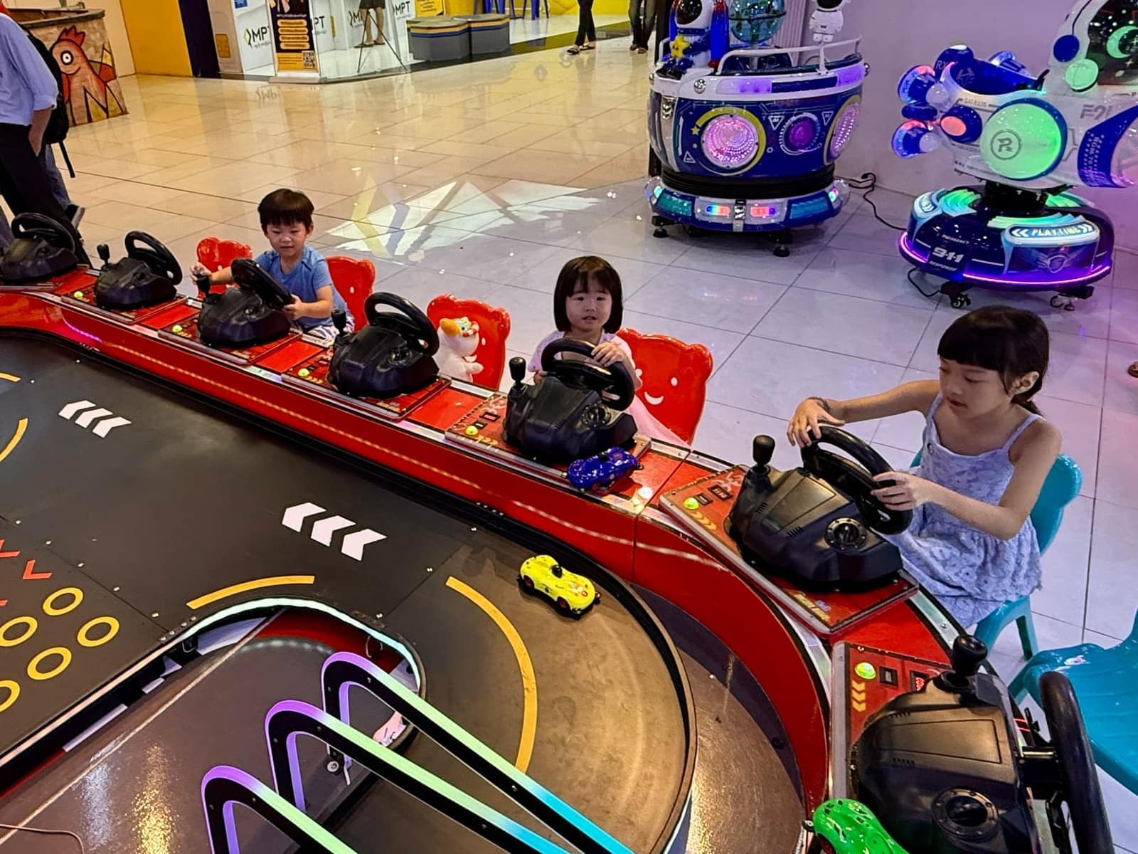 Sophie, George and Claire playing an arcade racing game together